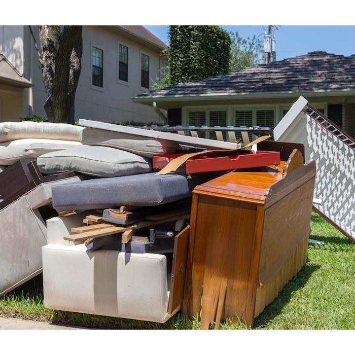 water damaged household furniture sitting outside on front lawn